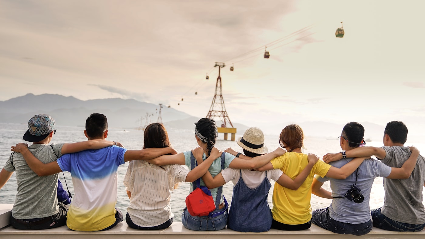 Friends sitting together with their arms around each other