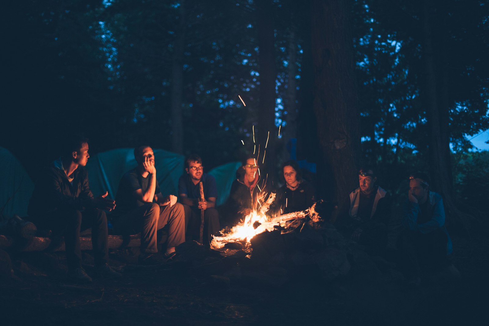 Friends sitting around a campfire in the woods